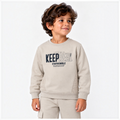Young boy wearing a beige victor and jane graphic fleece sweatshirt with Keep Real text and matching jogger pants.