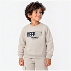 Young boy wearing a beige victor and jane graphic fleece sweatshirt with Keep Real text and matching jogger pants.