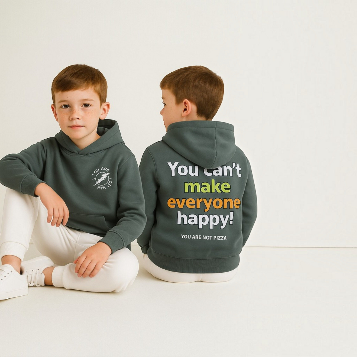 victor and jane boys olive green hoodie with graphic print on front and back, worn by a young boy sitting on floor