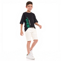 A young boy wearing a black victor and jane graphic t-shirt with green text and white denim shorts.