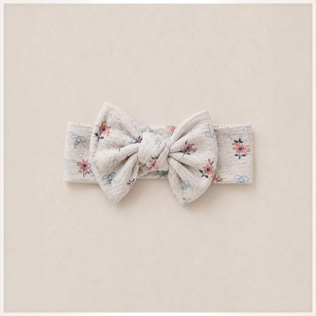 victor and jane baby girl headband in cream with a floral and bow print featuring a large knotted bow detail