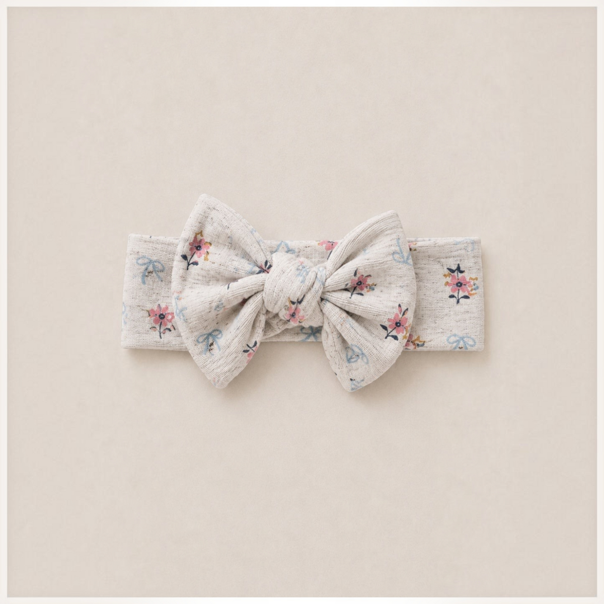 victor and jane baby girl headband in cream with a floral and bow print featuring a large knotted bow detail