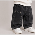 victor and jane boys black denim pants with contrast stitching and metal rivet details paired with white sneakers
