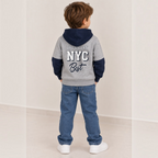 victor and jane grey and navy varsity hoodie with Brooklyn NYC graphic on back worn by a boy in blue jeans