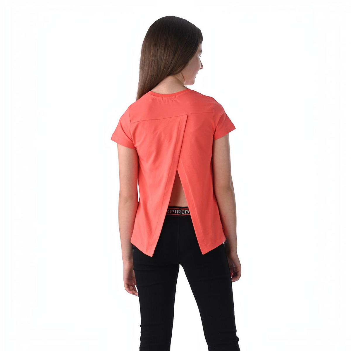 A girl wearing a coral victor and jane short-sleeve top with an open back design and black leggings.