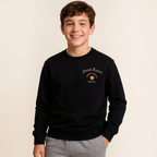 A smiling boy wearing a black victor and jane graphic sweatshirt with French Riviera text and a star design.