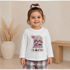 victor and jane girls white long sleeve top with cute cartoon graphic print worn by a smiling toddler