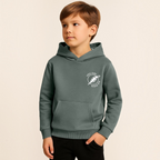 Young boy wearing a victor and jane olive green hoodie with a white circular graphic print on the chest