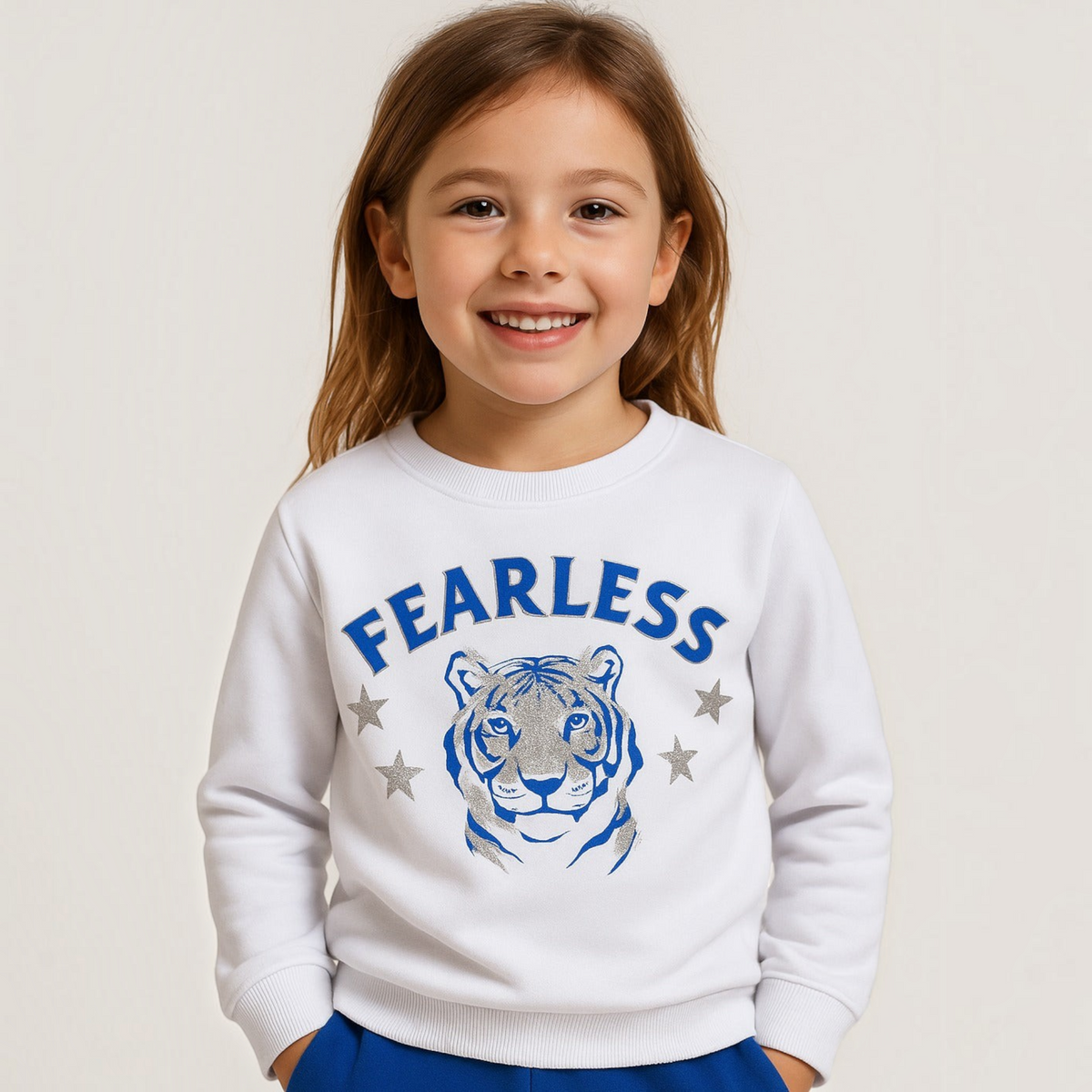 victor and jane white cotton sweatshirt with a blue tiger graphic and FEARLESS text worn by a smiling young girl