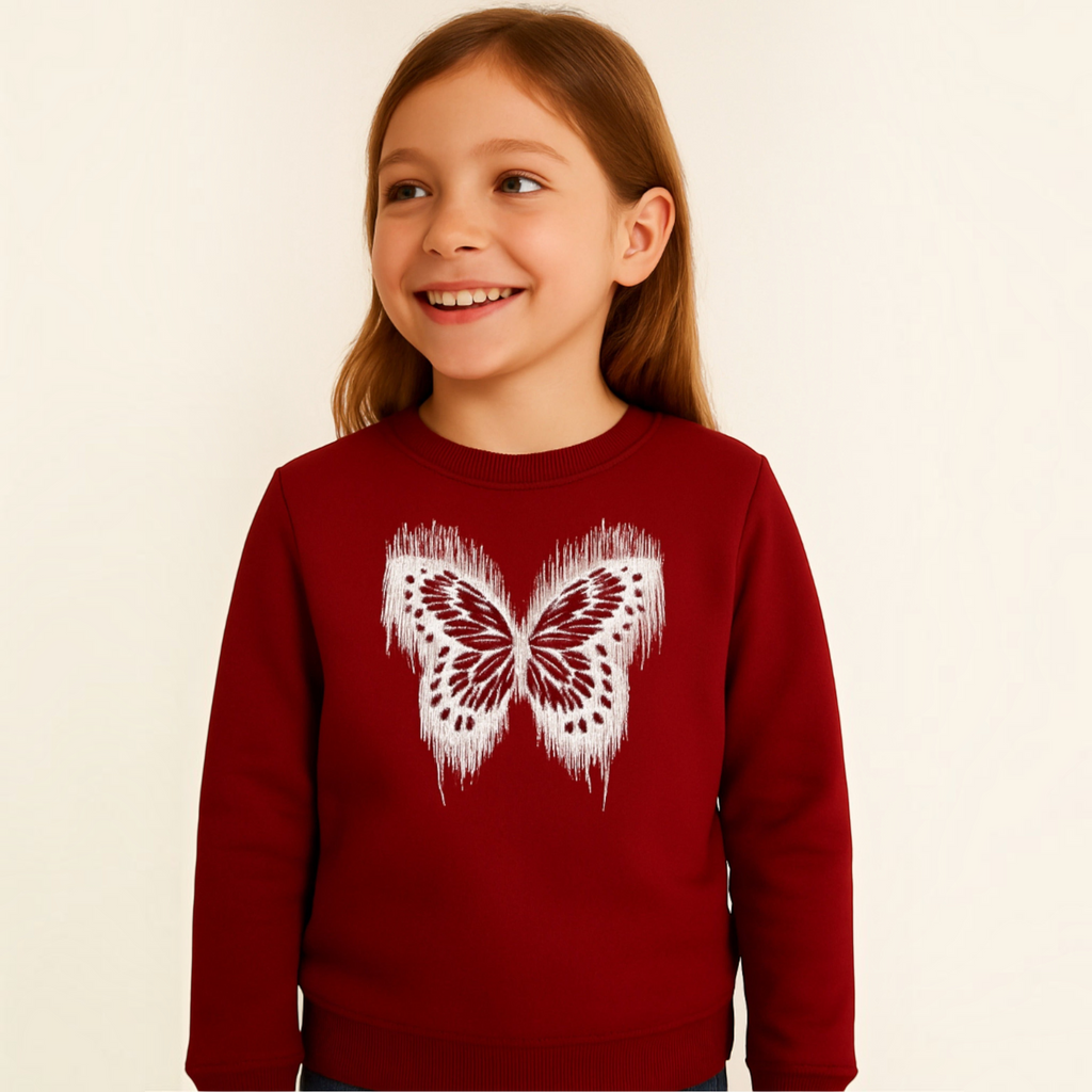 A young girl wearing a deep red victor and jane sweatshirt featuring a white distressed butterfly graphic print.