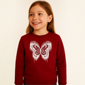 A young girl wearing a deep red victor and jane sweatshirt featuring a white distressed butterfly graphic print.