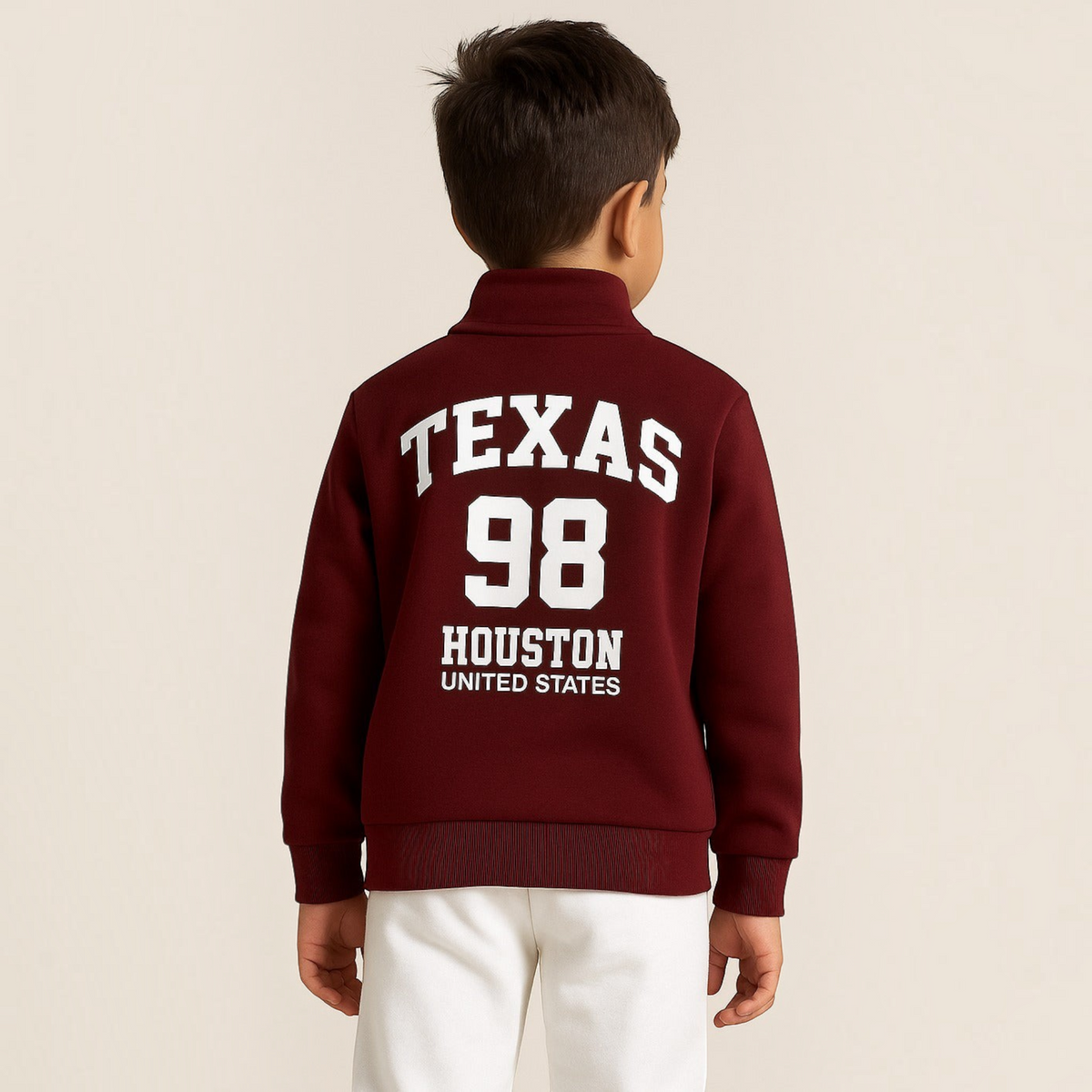 Back view of a boy wearing a maroon victor and jane zip-up jacket with white Texas 98 Houston United States lettering.