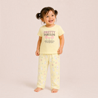 A toddler girl wearing a yellow victor and jane pyjama set with a bunny print and Pretty Fabulous graphic text