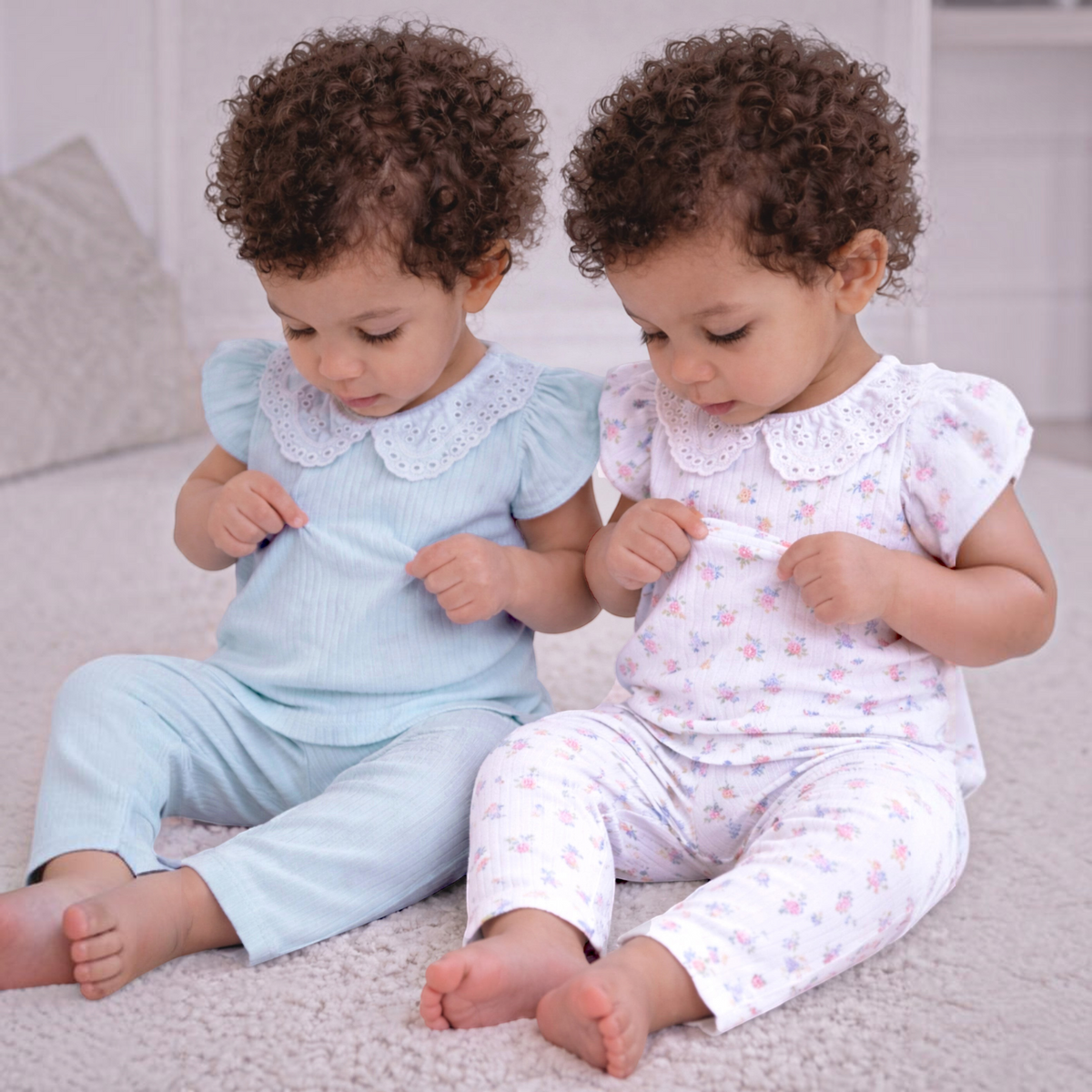 Two toddler girls wearing victor and jane 2-piece ribbed shirt and pant sets with white eyelet lace collars