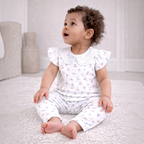 victor and jane baby girl wearing a white ribbed two-piece shirt and pants set with floral print and eyelet collar