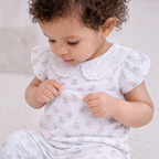 Toddler girl wearing a victor and jane white ribbed shirt set with floral print and a delicate eyelet lace collar.