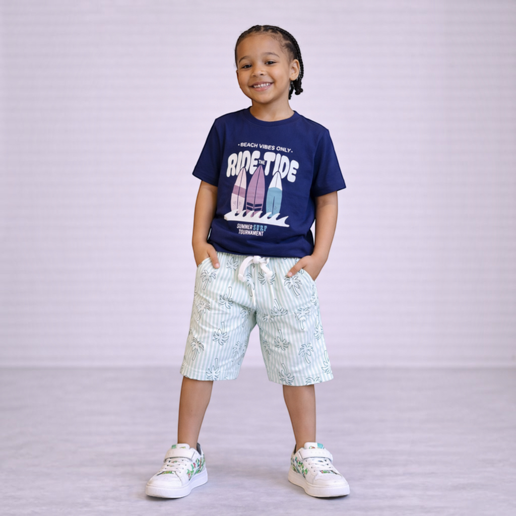 victor and jane boys graphic t-shirt with surf print and striped palm tree shorts on a smiling young boy
