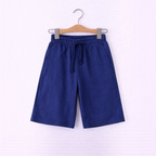 victor and jane boys blue cotton jersey shorts with an elastic drawstring waistband hanging on a wooden hanger