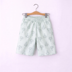 victor and jane boys light green striped shorts with white palm tree print hanging on a wooden hanger