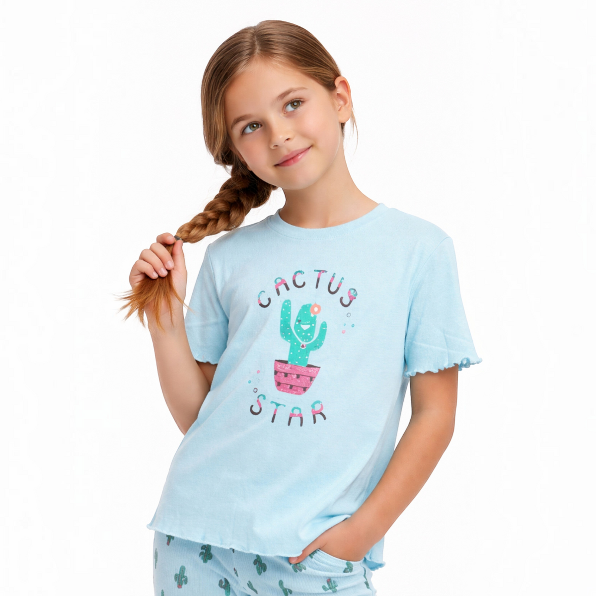 A young girl wearing a light blue victor and jane pyjama top with a cute cactus graphic and matching cactus print