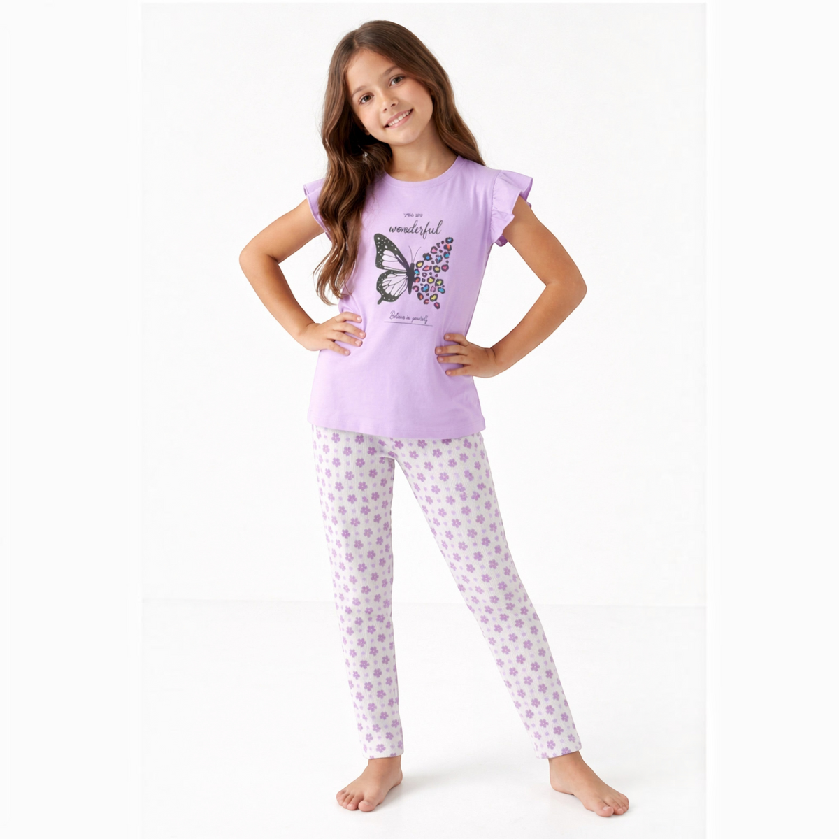 Young girl wearing a victor and jane lilac pyjama set with a butterfly graphic top and floral print leggings
