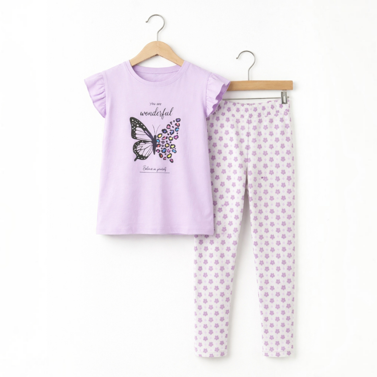 victor and jane girls lavender pyjama set with butterfly graphic top and floral print leggings on wooden hangers
