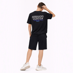 victor and jane boys black t-shirt and shorts set with white graphic print on back, worn by a model from behind