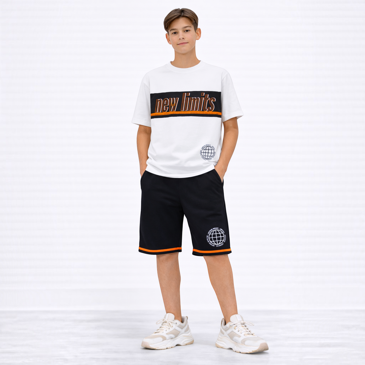 victor and jane boys white t-shirt and black shorts set with orange accents and graphic print on a young model