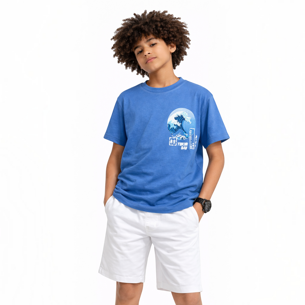 victor and jane boys blue graphic t-shirt with wave print worn by a young boy with curly hair and white shorts