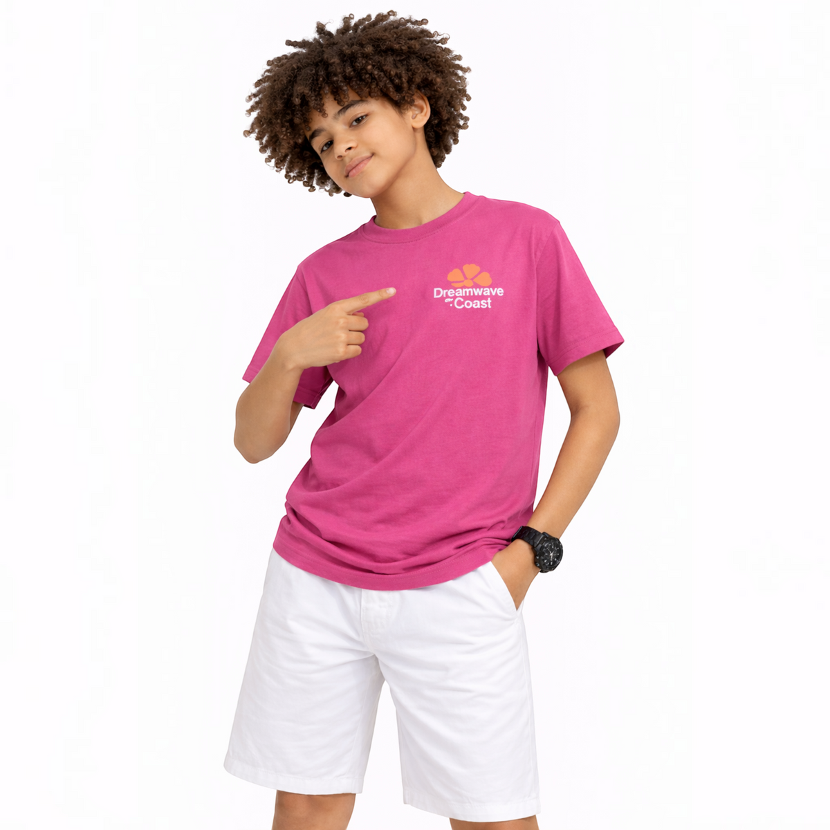 A boy wearing a pink victor and jane graphic t-shirt with a Dreamwave Coast logo and white shorts