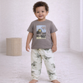 Toddler boy wearing a victor and jane grey t-shirt with a dinosaur print and matching patterned joggers