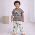 Toddler boy wearing a victor and jane grey t-shirt with a dinosaur print and matching patterned joggers