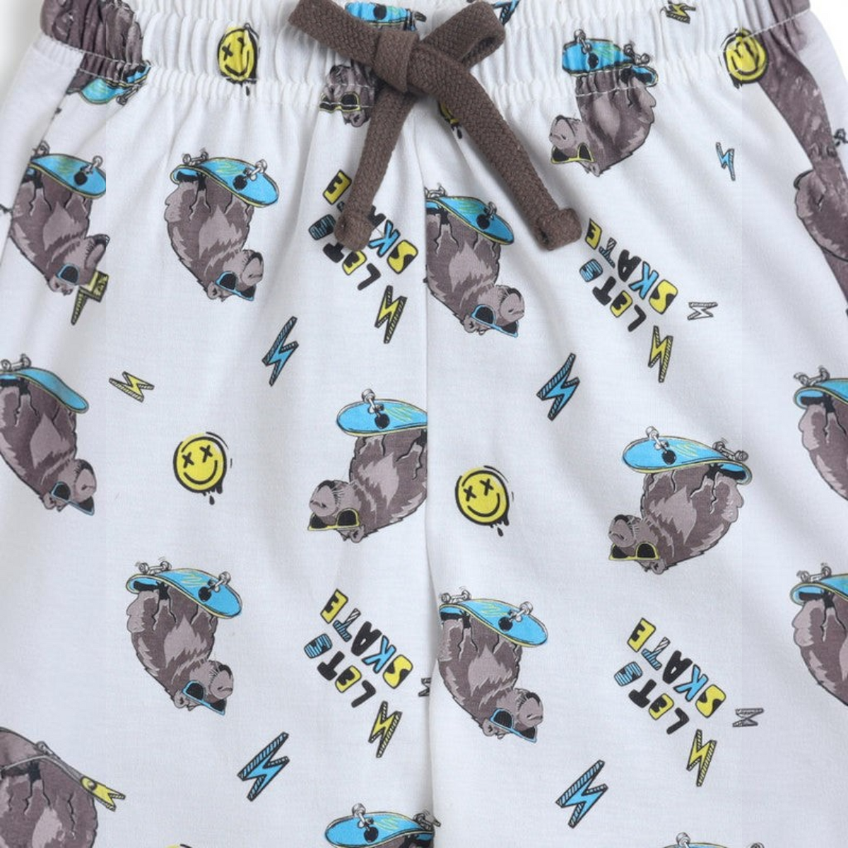 victor and jane boys white cotton shorts featuring a playful print of skating capybaras, smiley faces, and lightning