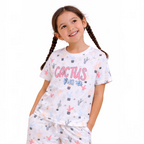 A young girl smiling while wearing a victor and jane white t-shirt featuring a colorful cactus print and text.