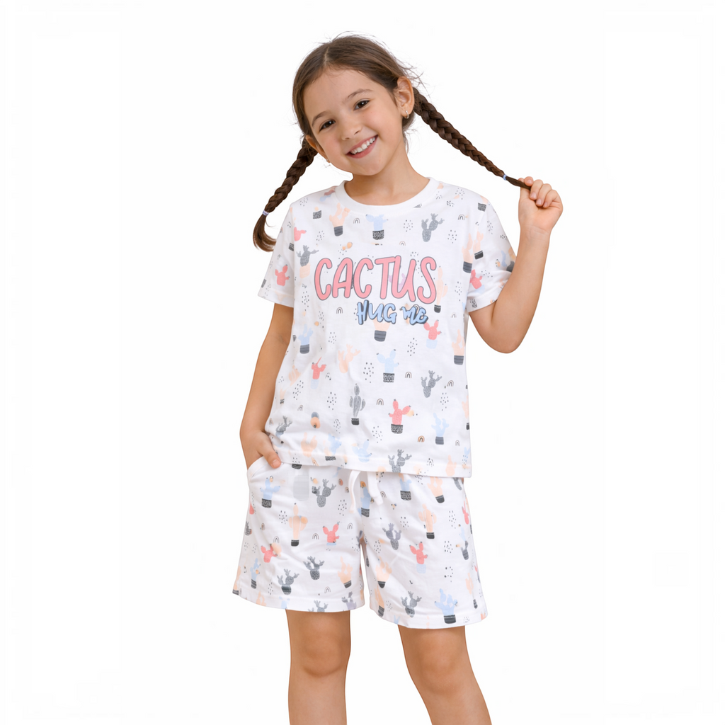 A young girl wearing a victor and jane white short-sleeve t-shirt and shorts set with a cactus print and text.
