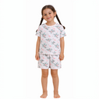 Young girl wearing a victor and jane white short-sleeve t-shirt and shorts set with a pink flamingo and leaf print.