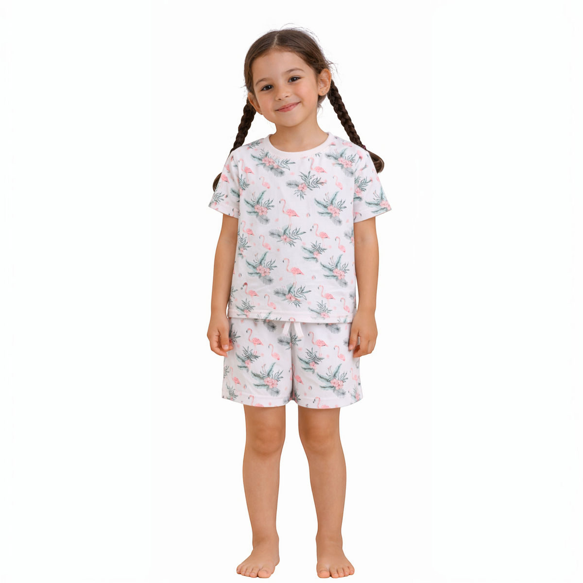 Young girl wearing a victor and jane white short-sleeve t-shirt and shorts set with a pink flamingo and leaf print.