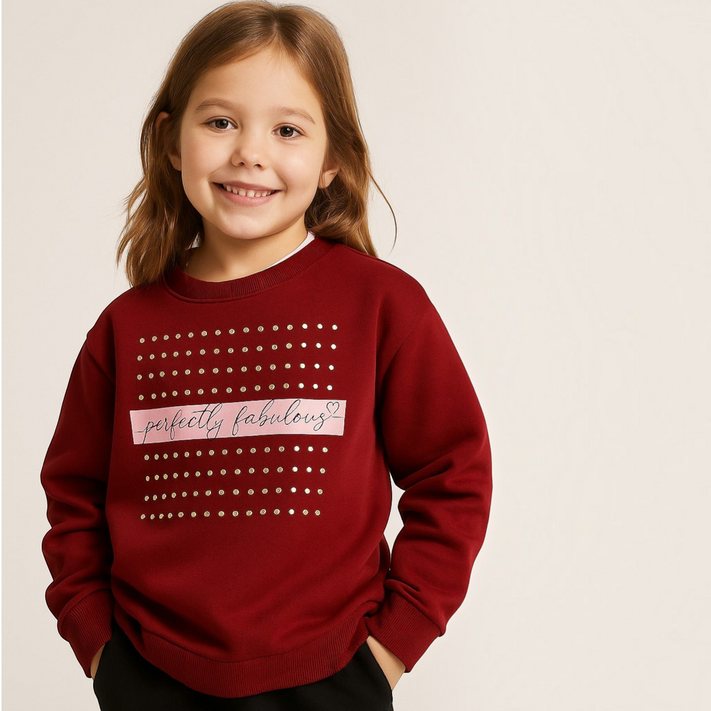 Young girl wearing a burgundy victor and jane EURA sweatshirt with gold stud details and perfectly fabulous text