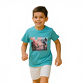 A young boy smiling while wearing a turquoise victor and jane graphic t-shirt featuring a bicycle print
