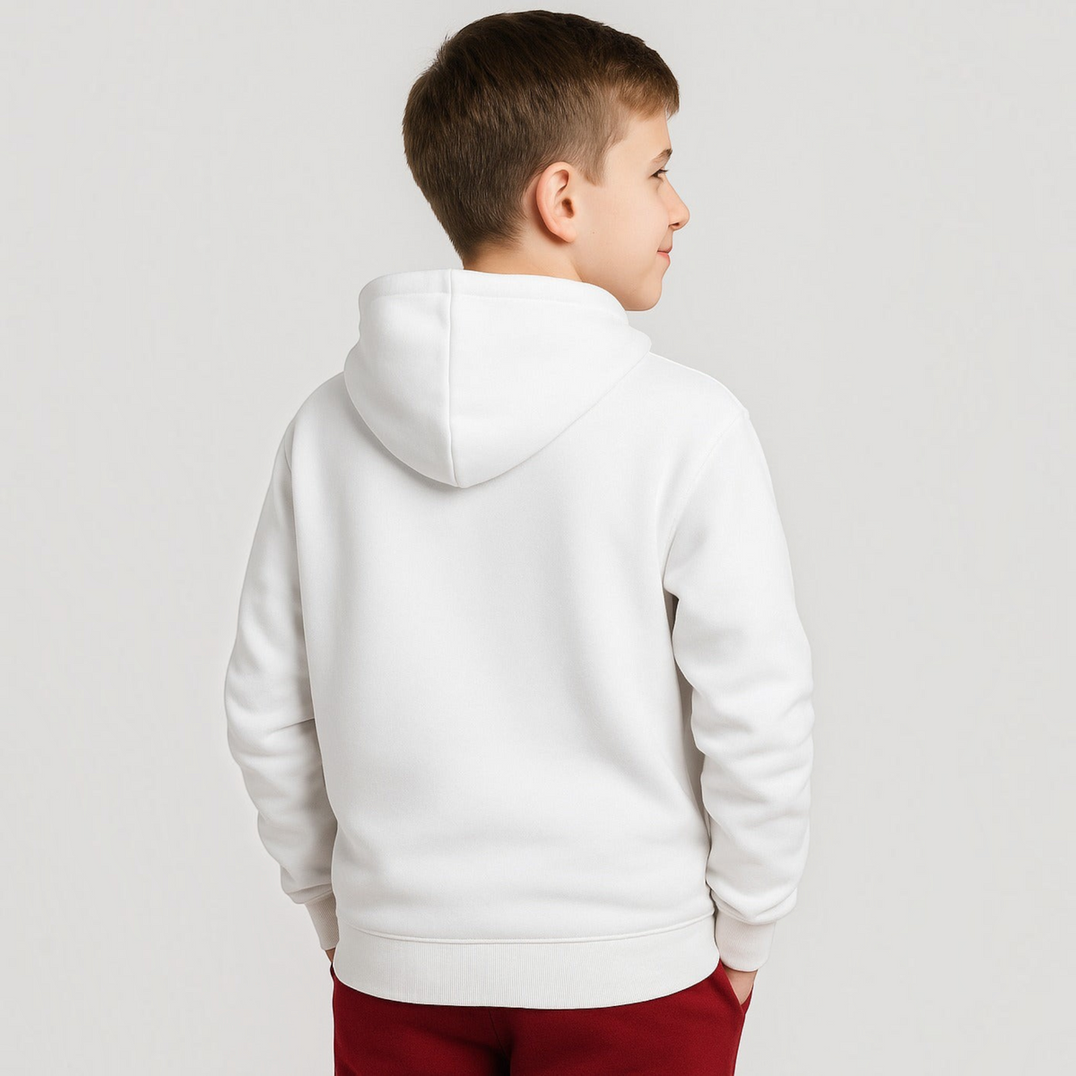 A young boy wearing a plain white victor and jane hooded sweatshirt, viewed from the back against a grey background.