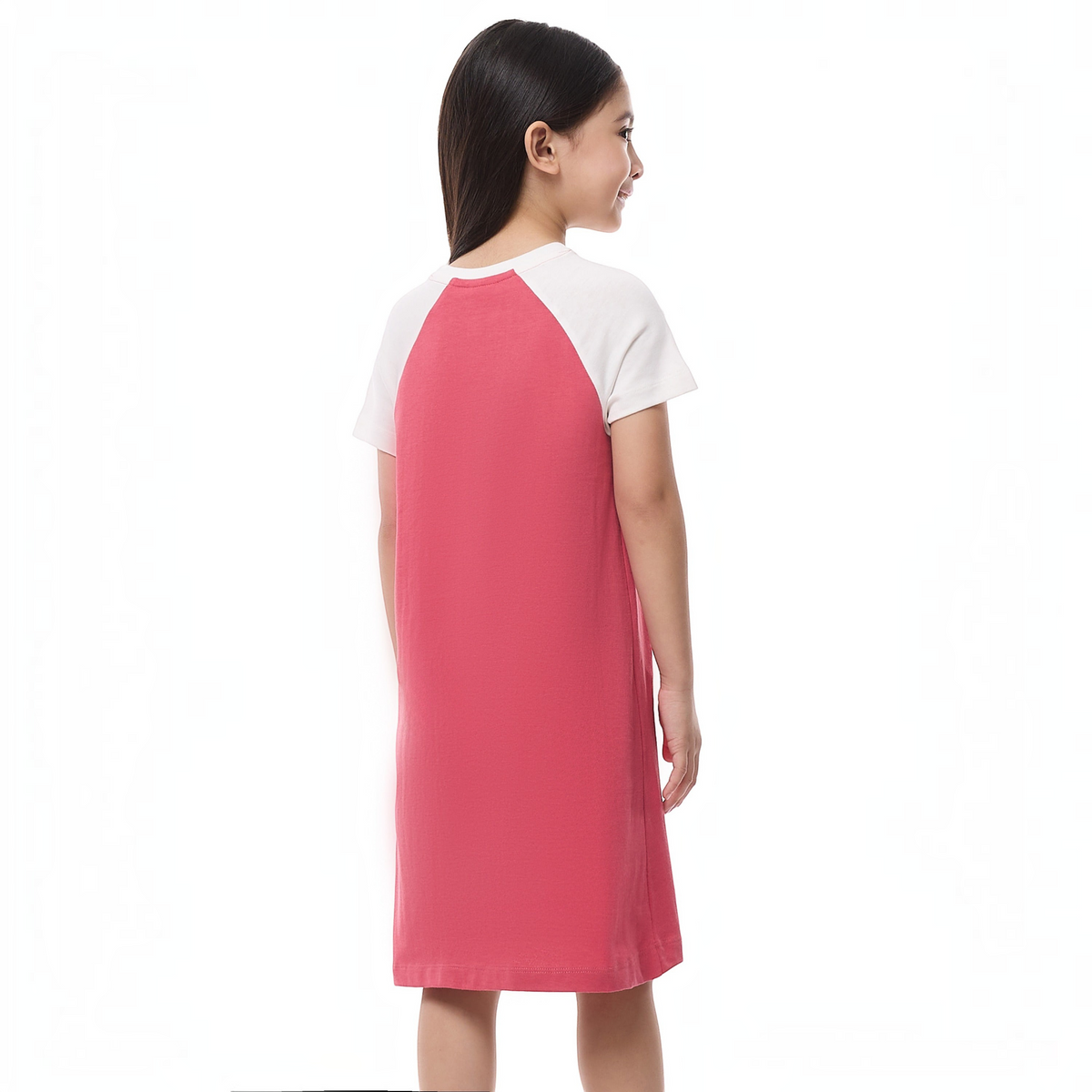 A young girl wearing a victor and jane pink and white raglan sleeve pajama dress, back view.
