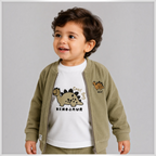 Toddler boy wearing a victor and jane olive green corduroy zip jacket over a white dinosaur print t-shirt