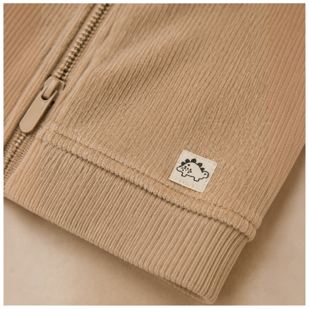 victor and jane boys beige corduroy zip jacket detail with a small dinosaur patch on the ribbed hem