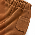 Close-up of brown knit cargo pants from victor and jane featuring an elastic waistband and a patch pocket.