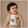 victor and jane 3-piece set featuring a beige corduroy zip jacket and white dinosaur graphic t-shirt on a toddler